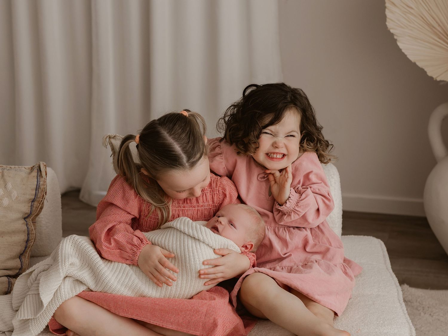 Siblings sharing sweet moments in matching pink outfits.