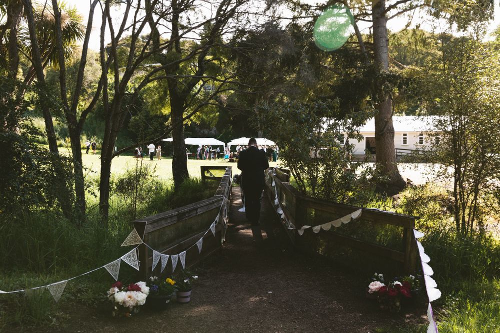 Outdoor wedding ceremony setup with bunting decorations and trees in background.