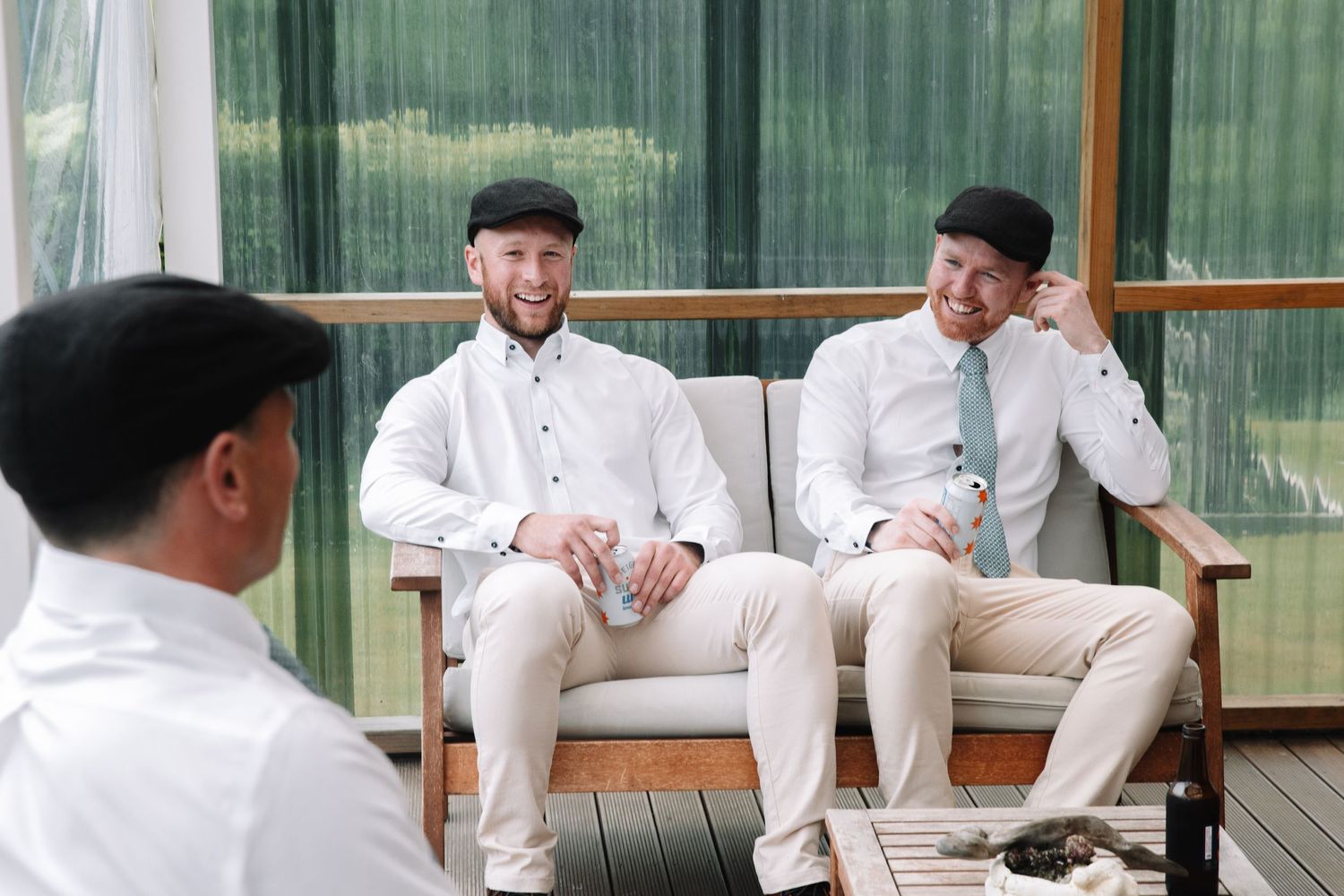Group of friends in formal attire sharing a laugh on an outdoor patio.
