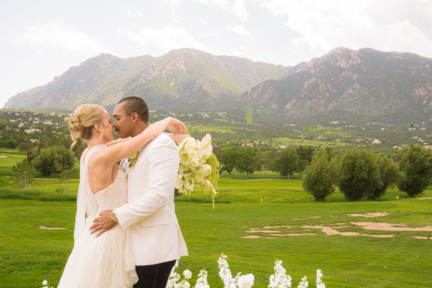 Colorado Springs Wedding Photographer. Photo of the bride and groom posing in front of the mountains.