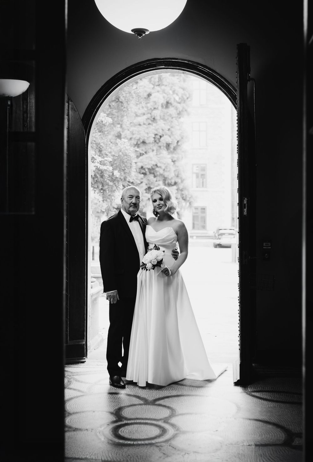 Black and white wedding photos show a couple silhouetted in arched doorways of a classic architectural setting.