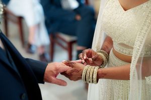 A close-up shot of hands exchanging rings during a wedding ceremony.