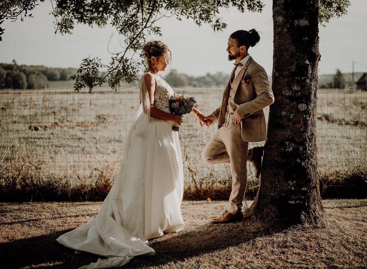 A stunning wedding photography sequence under trees showing romantic moments between a couple in white dress and suit.