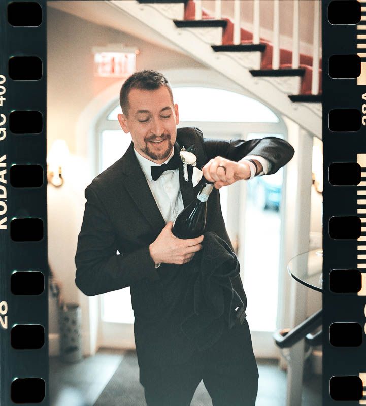 Groom Pops Cork after Ceremony Christ First Church Fox Chapel Pittsburgh PA shot on 35mm film.