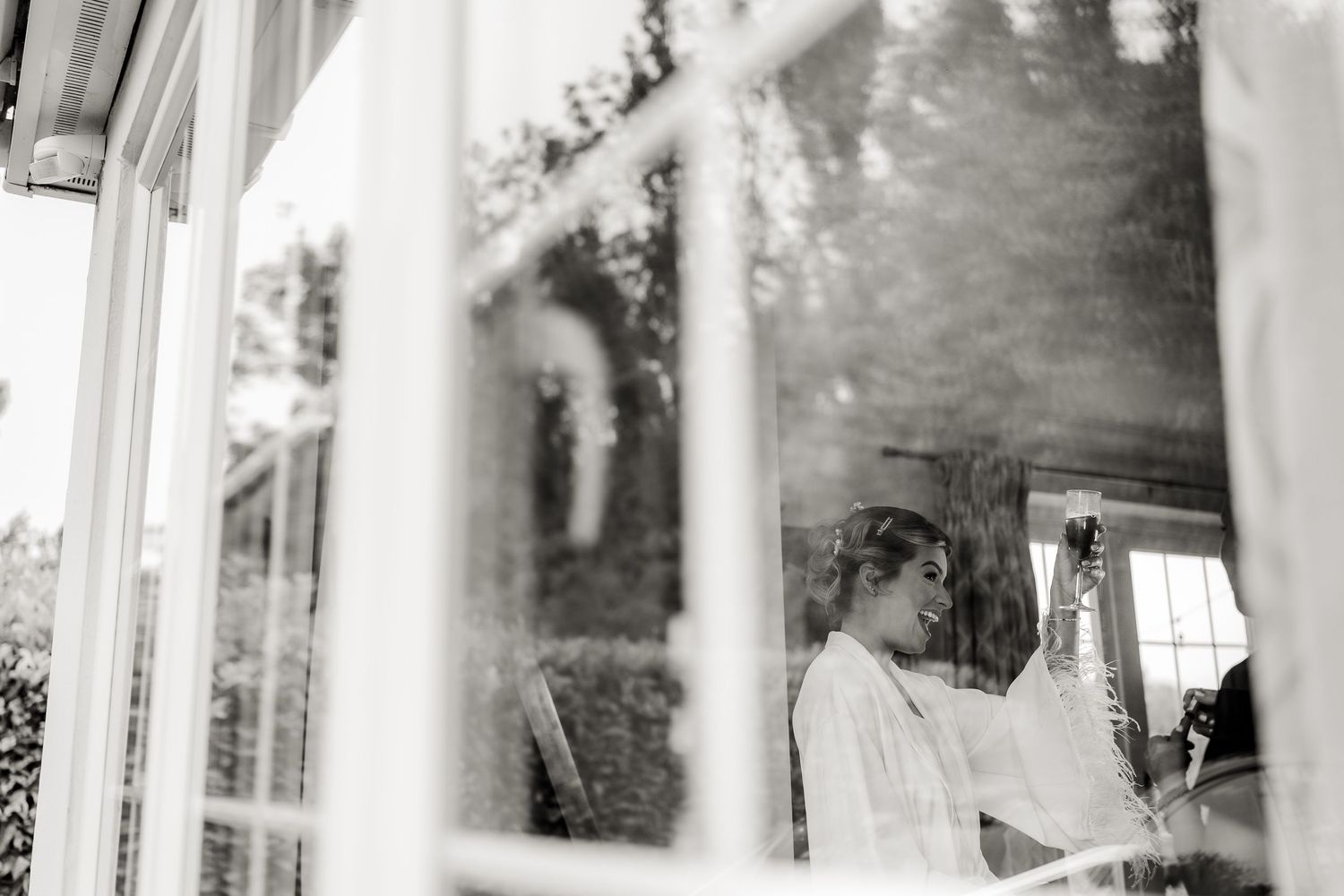 Black and white photo showing a person through window panes at an outdoor venue.