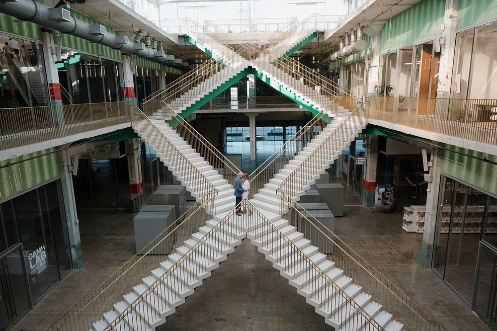 Aerial view of a modern shopping center with crisscrossing staircases forming an X pattern in Hong Kong.