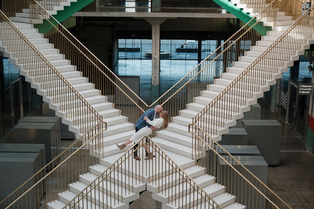 Modern architecture photography with symmetrical staircases crossing in a triangular pattern against a glass background.
