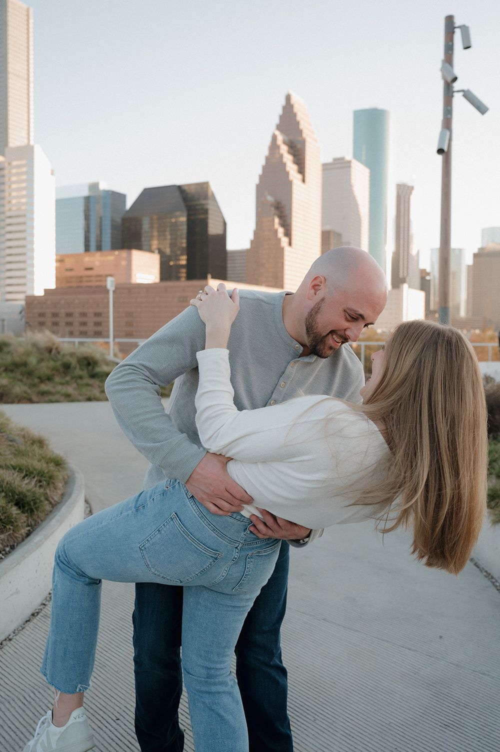 A romantic moment between a couple dancing on a rooftop with the Houston city skyline in the background.
