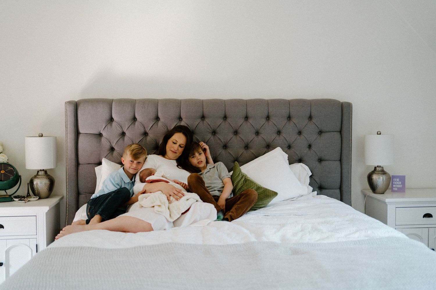 A cozy bedroom scene with soft morning light streaming in while family members share quiet moments together.