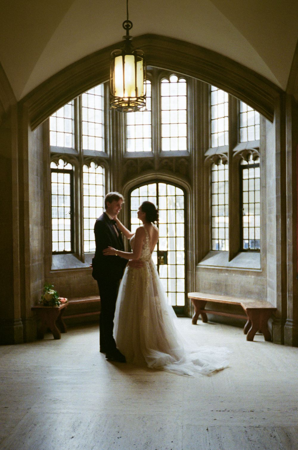 Sunlit gothic interior room with arched windows creates dramatic setting for formal portraits.