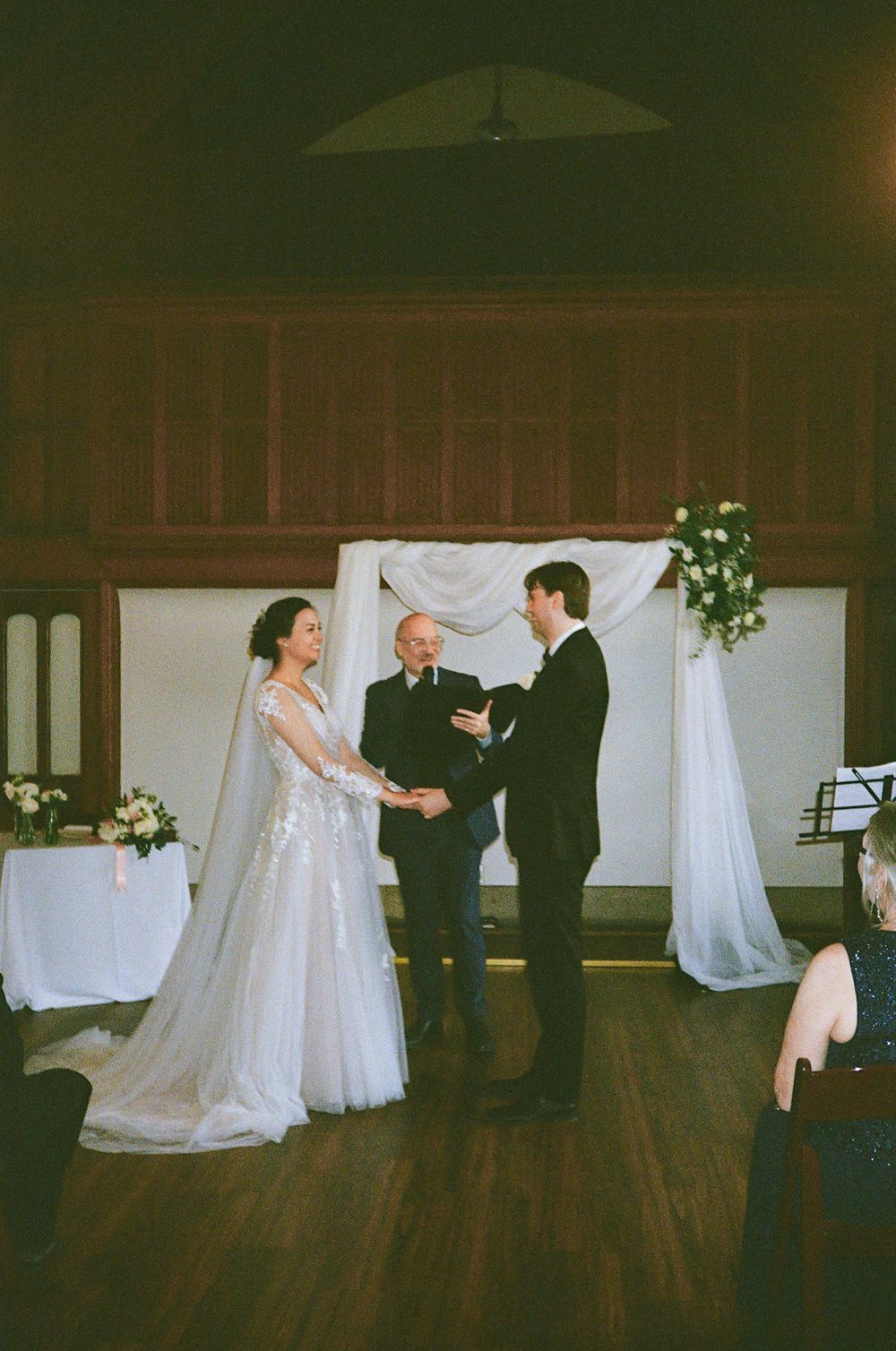 Wedding reception dance floor with white fabric backdrop and elegant lighting.