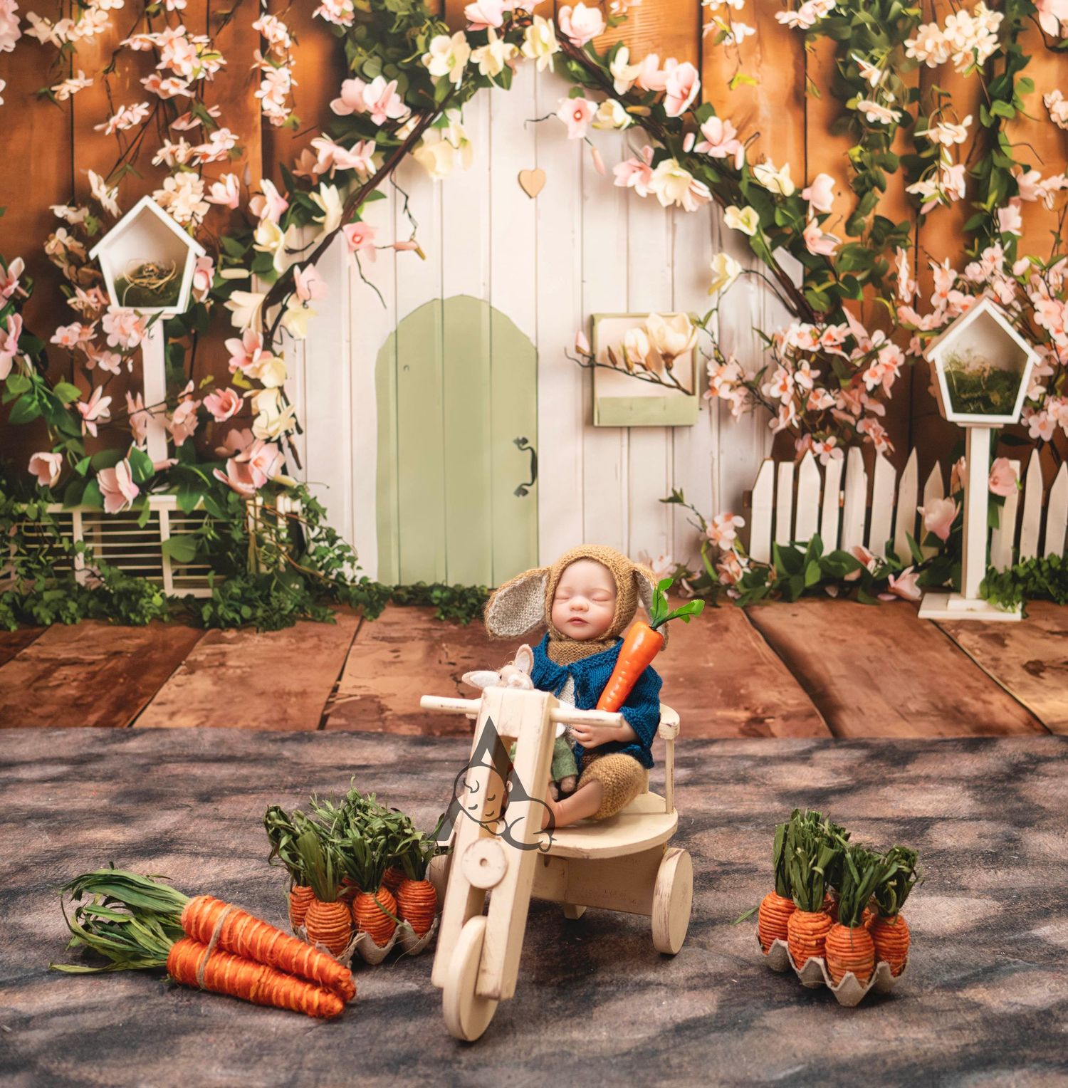 Whimsical garden setting with wooden backdrop, floral arch, and decorative carrots around small wooden chair.