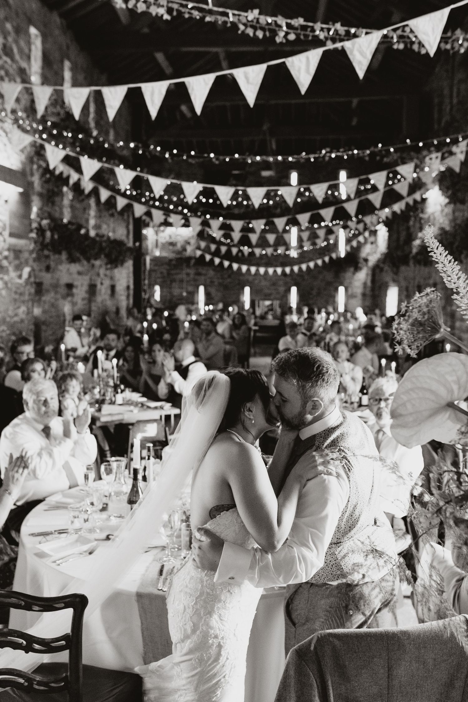 A romantic first dance at a court wedding reception under string lights and white bunting decorations at Lyde Court, Hereford.