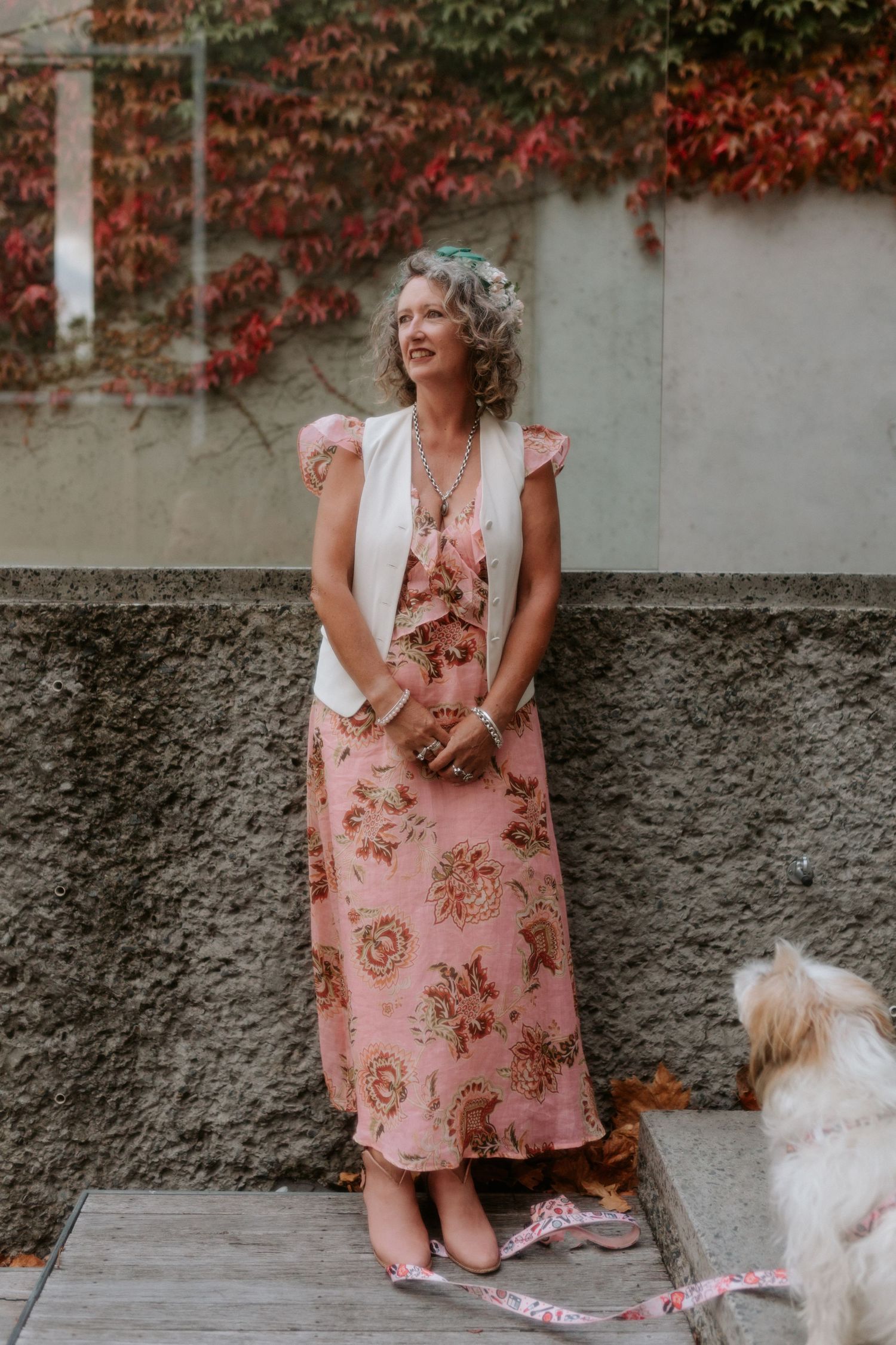 A vintage-style collage shows someone in a pink floral dress sitting against a stone wall with autumn ivy.
