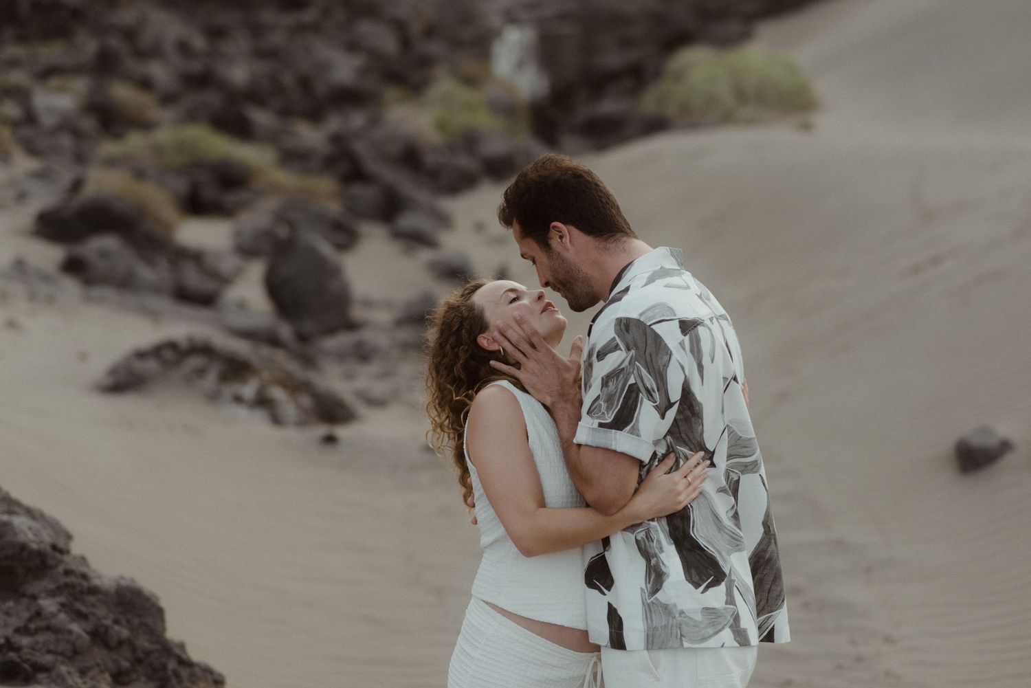 A couple shares an intimate moment together during a romantic beach photoshoot.