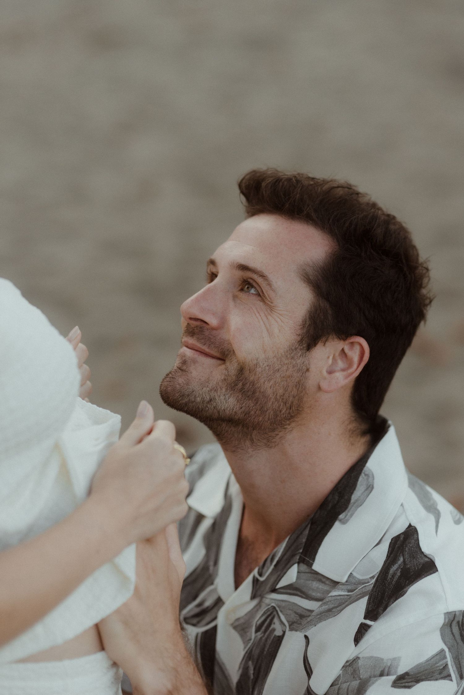 A series of photos show someone looking up and having their chin adjusted in a casual jacket or sweater.