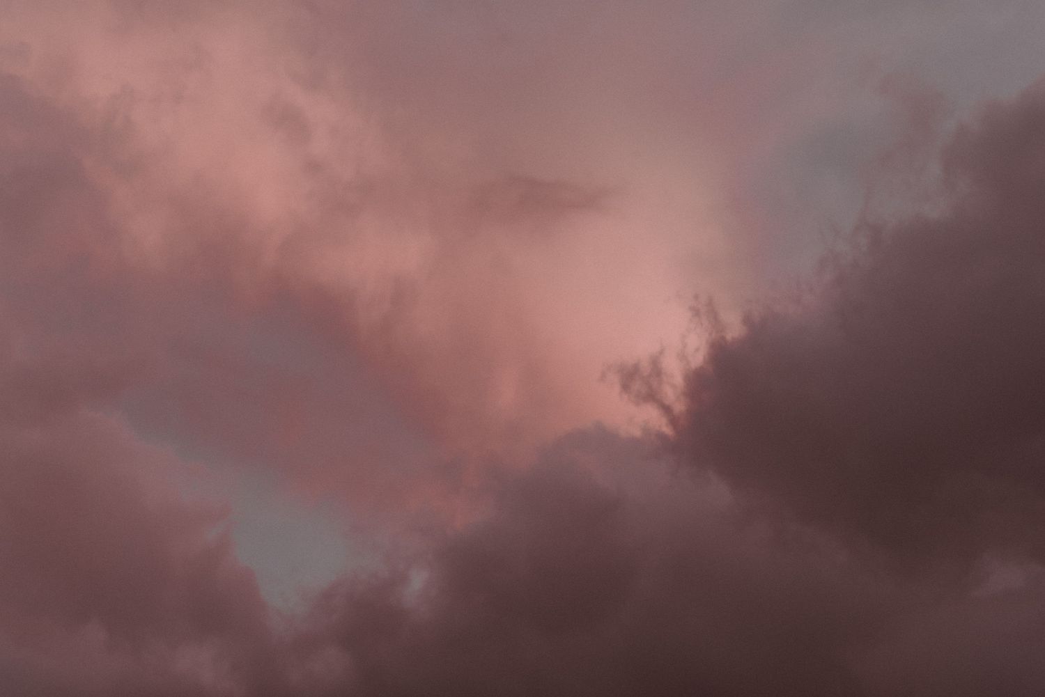 Dramatic pink and purple storm clouds fill the sky at dusk creating a moody atmospheric scene.