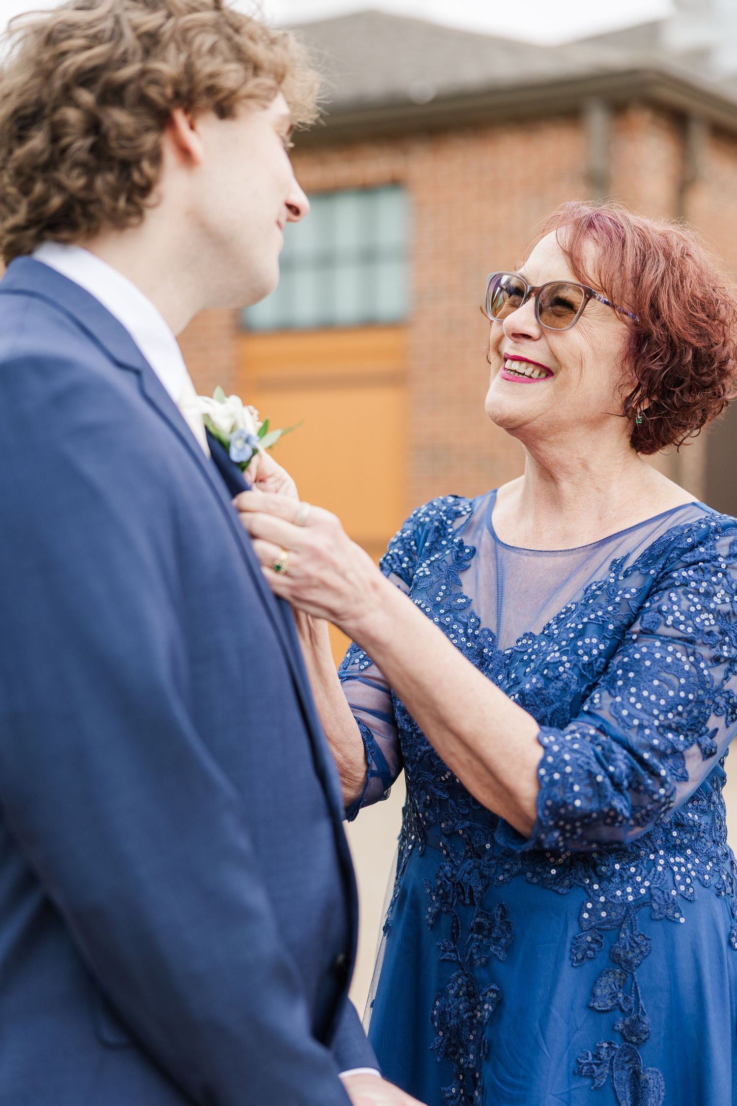 An intimate moment shared between two people, with one wearing a beaded navy blue dress and another in a dark suit.