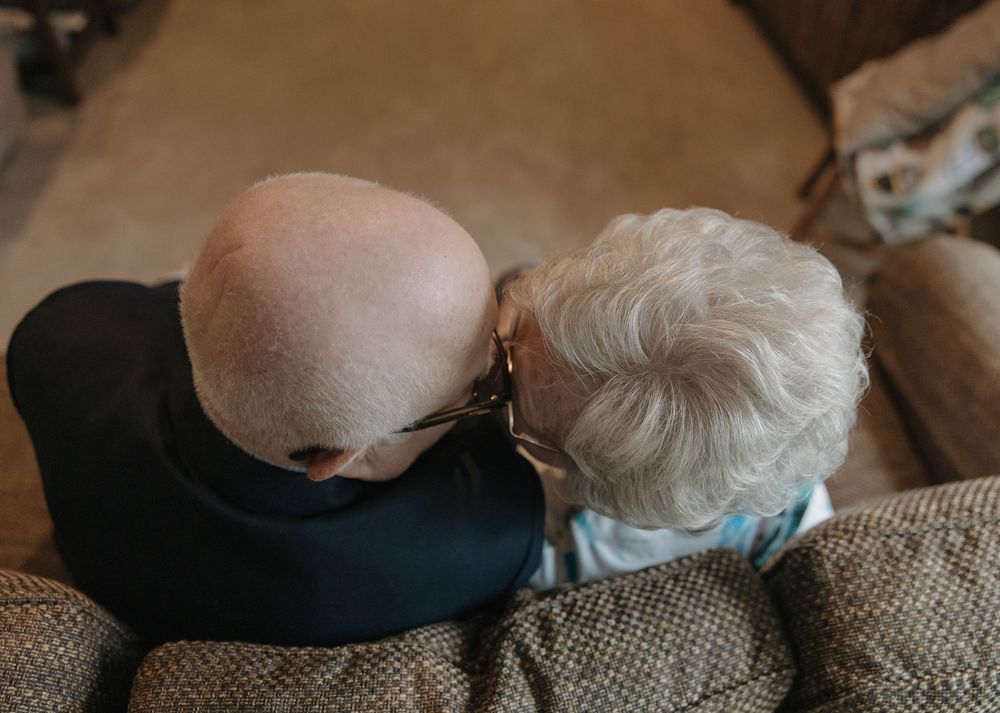 A person's head resting on a textured burlap or linen surface with soft, warm lighting creating a serene atmosphere.