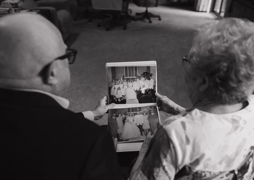 Two people looking at a vintage black and white photograph they are holding together.