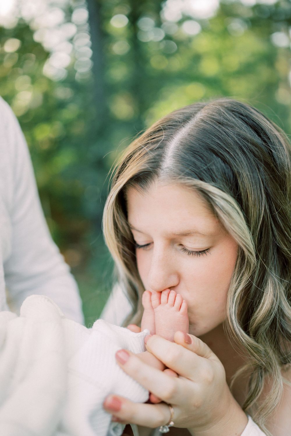 Intimate close-up moment with tiny baby feet in outdoor setting.