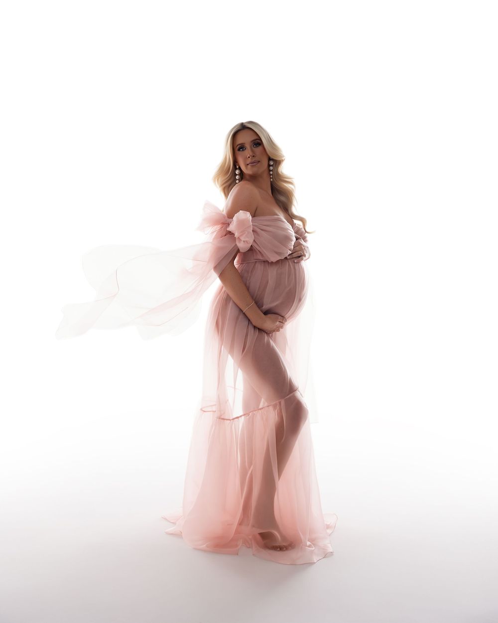 Four ethereal maternity images in soft pink showing a flowing gown against a white background.