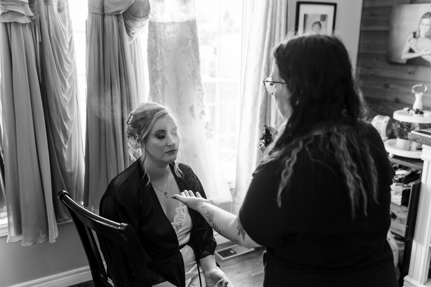 Makeup artist prepares someone for a professional photoshoot in a bright vanity light setting.
