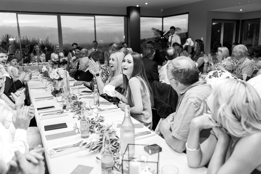 A large group of people seated at long banquet tables in a formal dining setting for a special event.