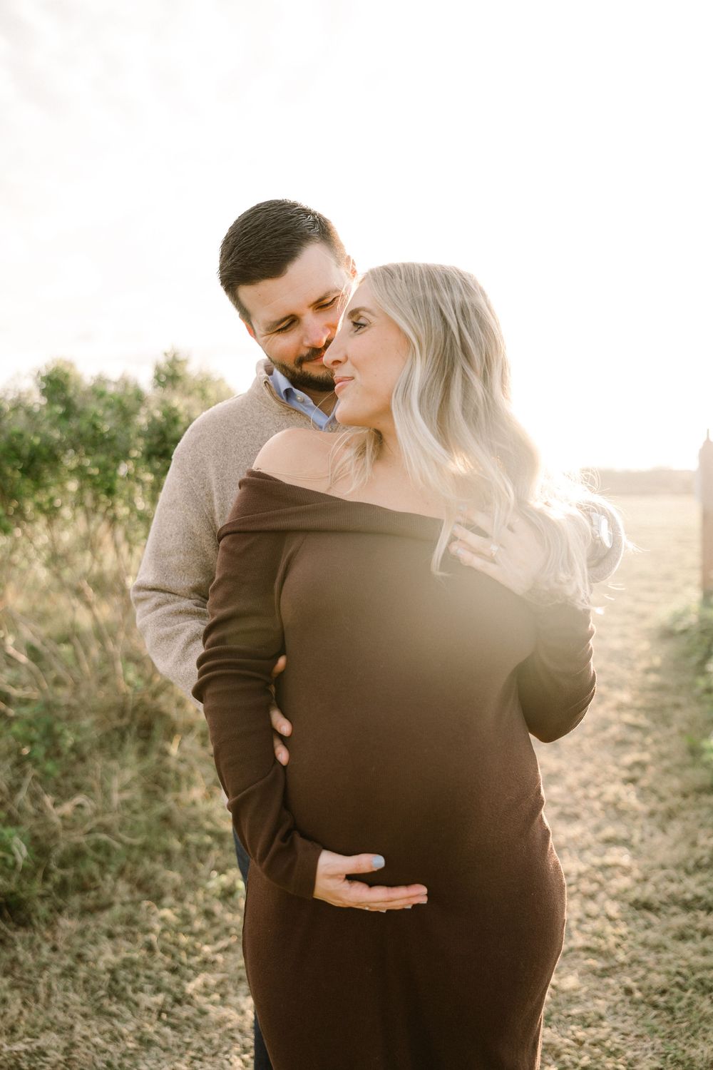 Intimate maternity portrait of couple in warm evening light.