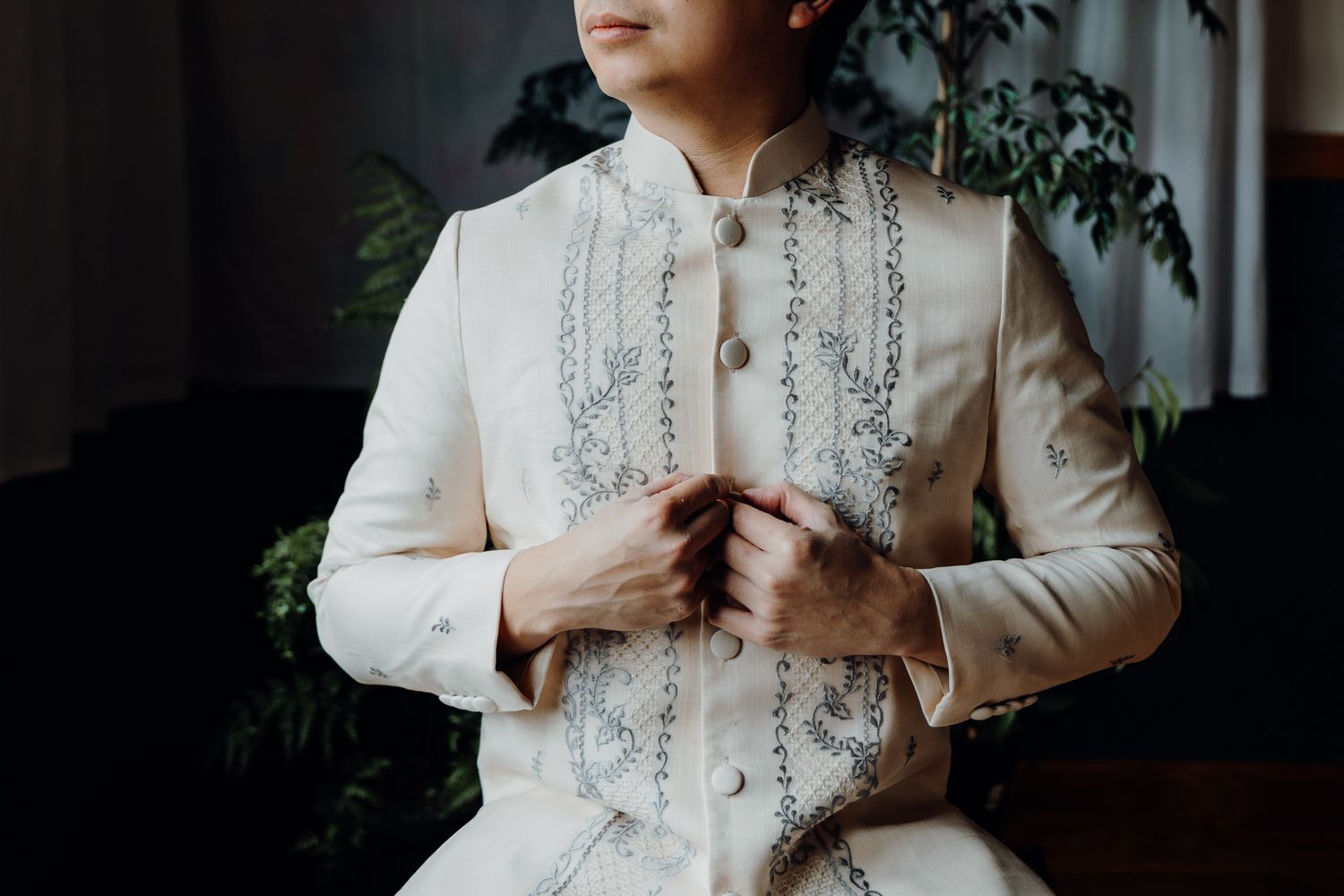 Traditional embroidered white Barong Tagalog formal wear with detailed stitching.