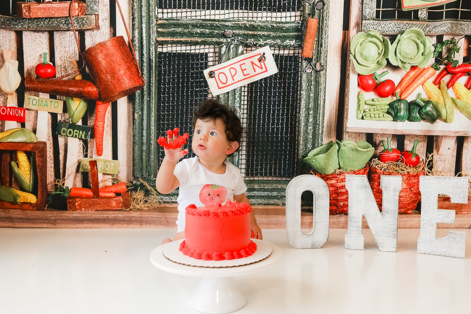Birthday setup with red smash cake and farm-themed decorations for first birthday celebration.