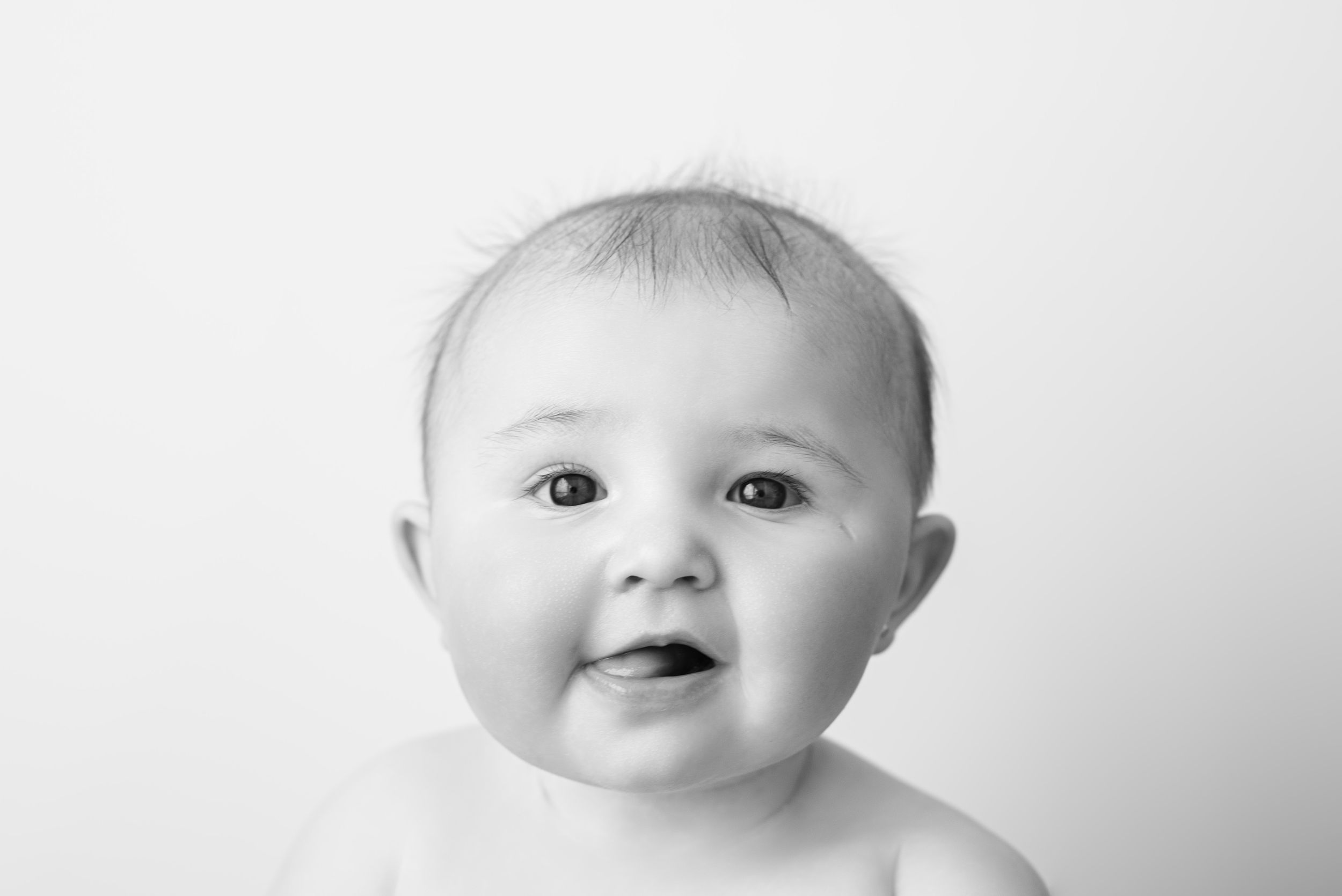 Close-up portrait of a baby against a white background.