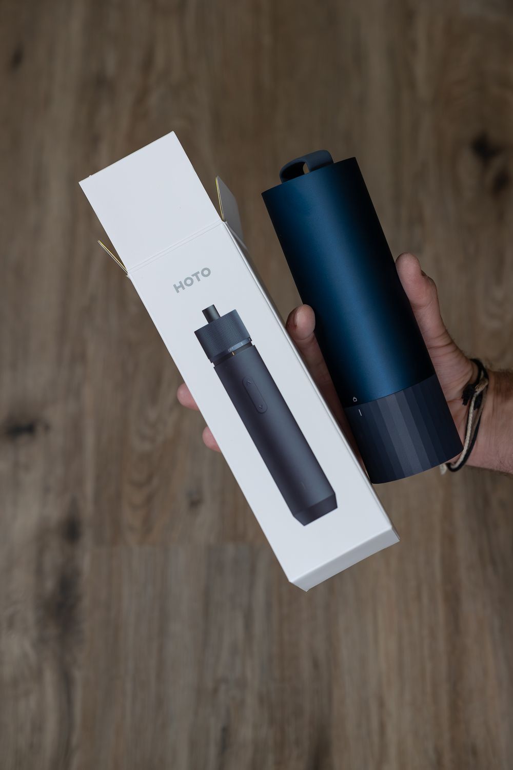 Black insulated water bottle being displayed next to its retail packaging.