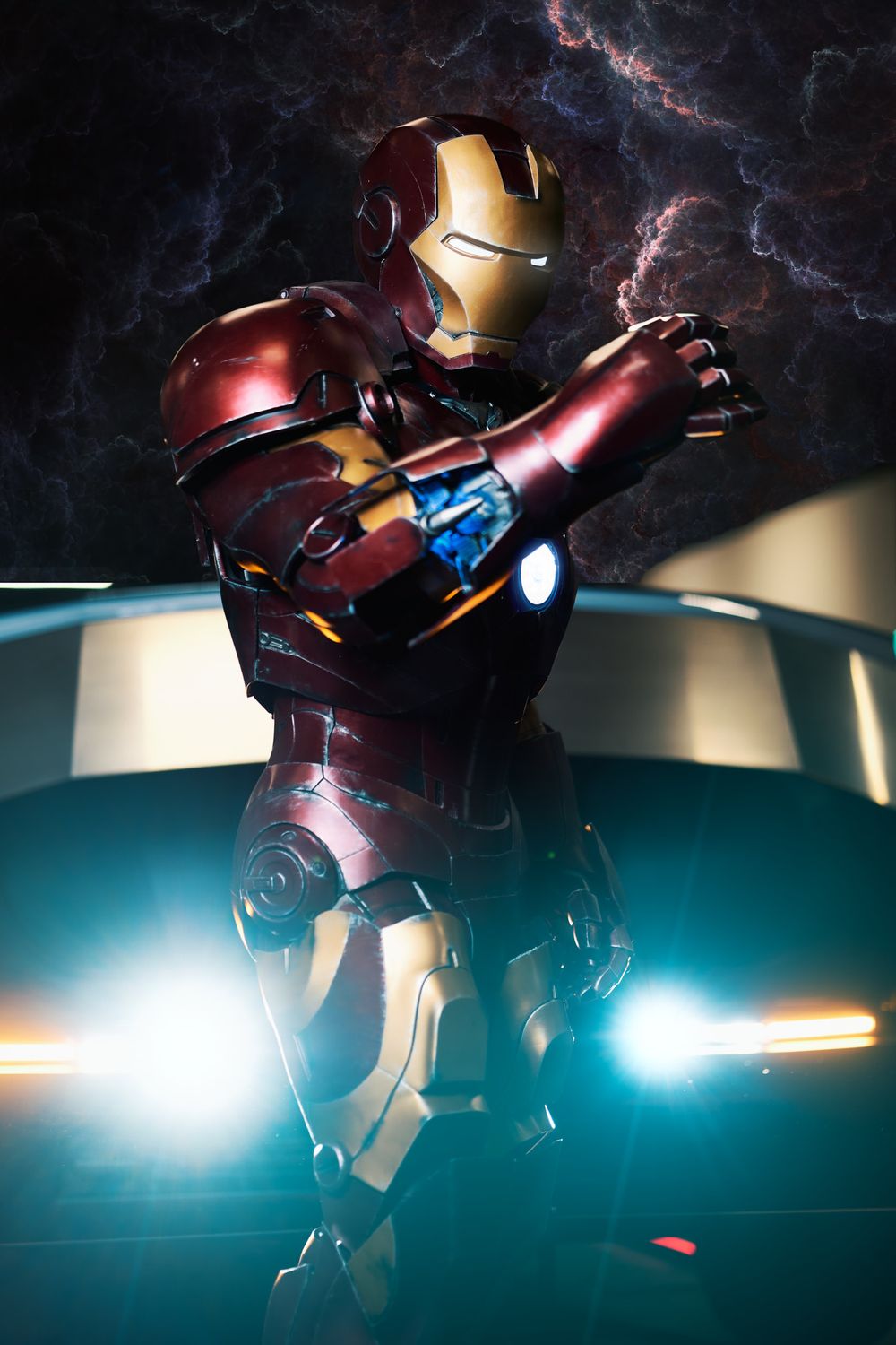 Iron Man suit standing in dramatic lighting with glowing chest reactor and lightning effects in the background.