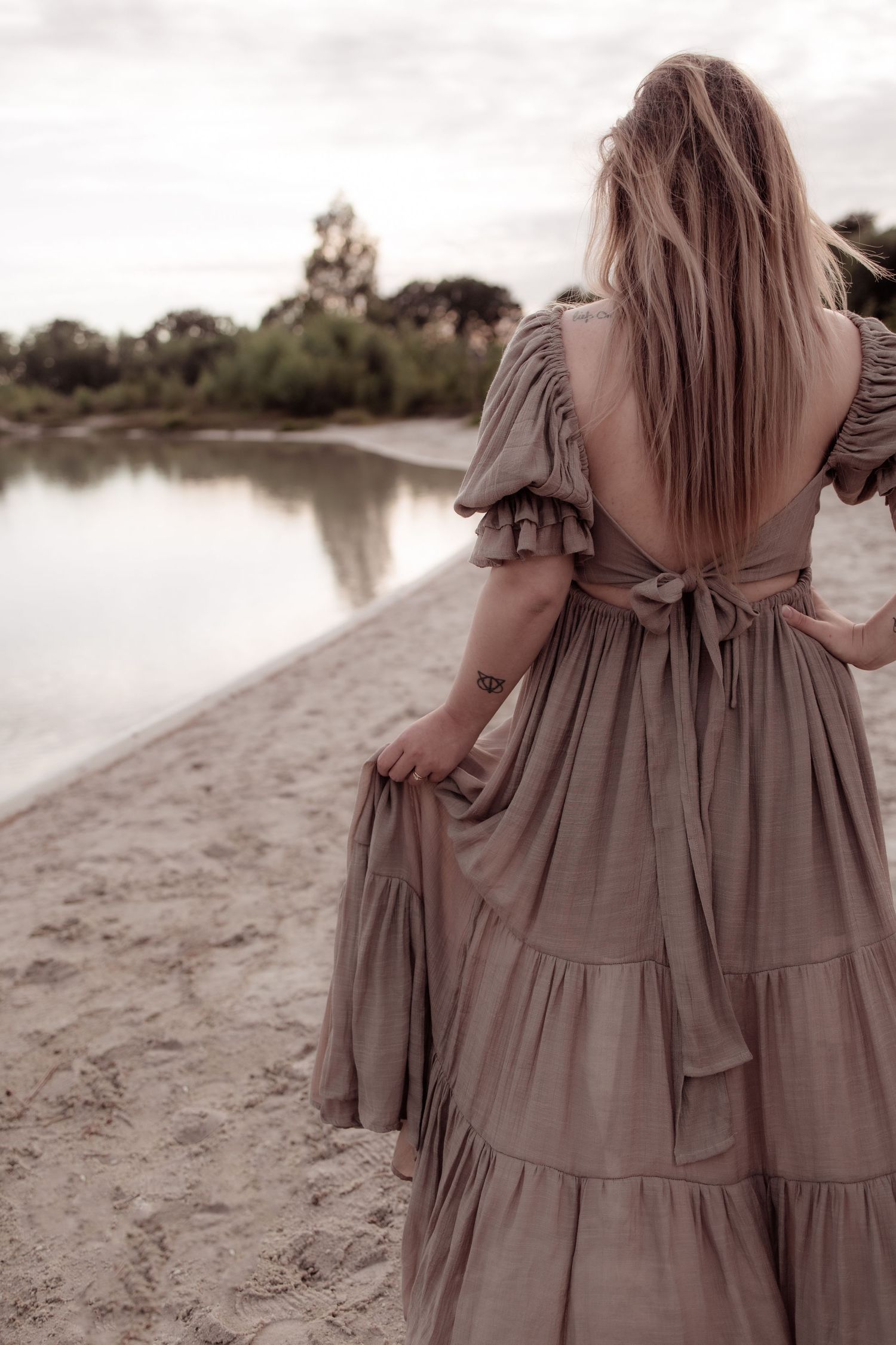 Zwangere vrouw in open veld bij zonsondergang met warme styling
Zwangerschapsfoto met los vallende jurk en ontspannen uitstraling