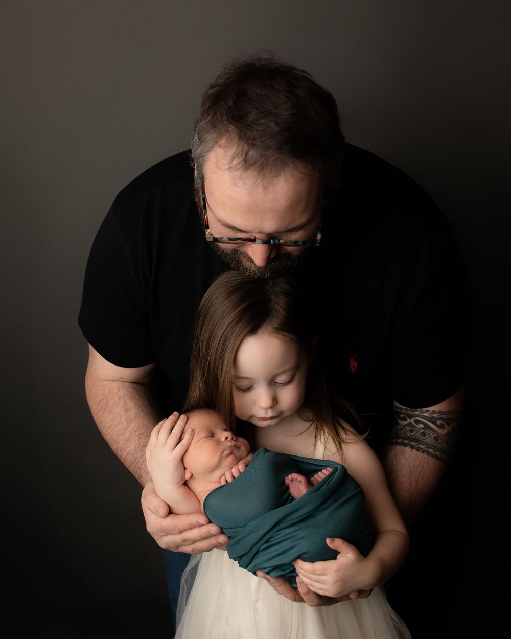 Professional newborn photo with dad and sister