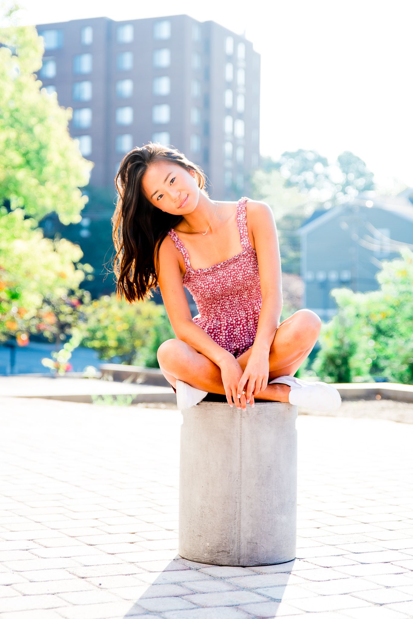 girl in red dress sitting on concrete block
