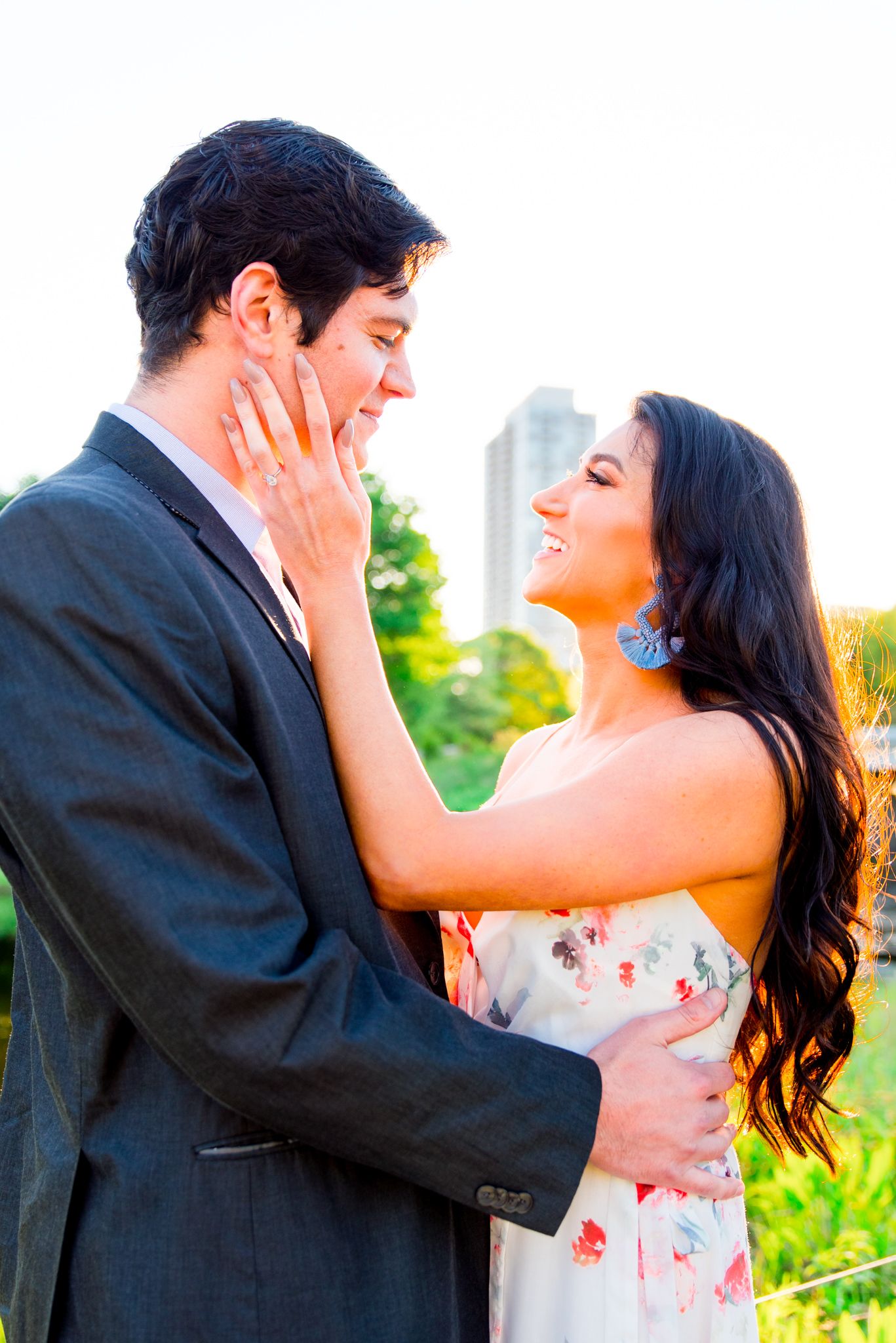 man and woman with dark hair and blue earrings looking at each other smiling for Lincoln Park Chicago engagement picture