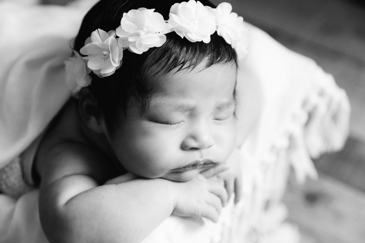 close up black and white profile of baby in boho prop flower headband