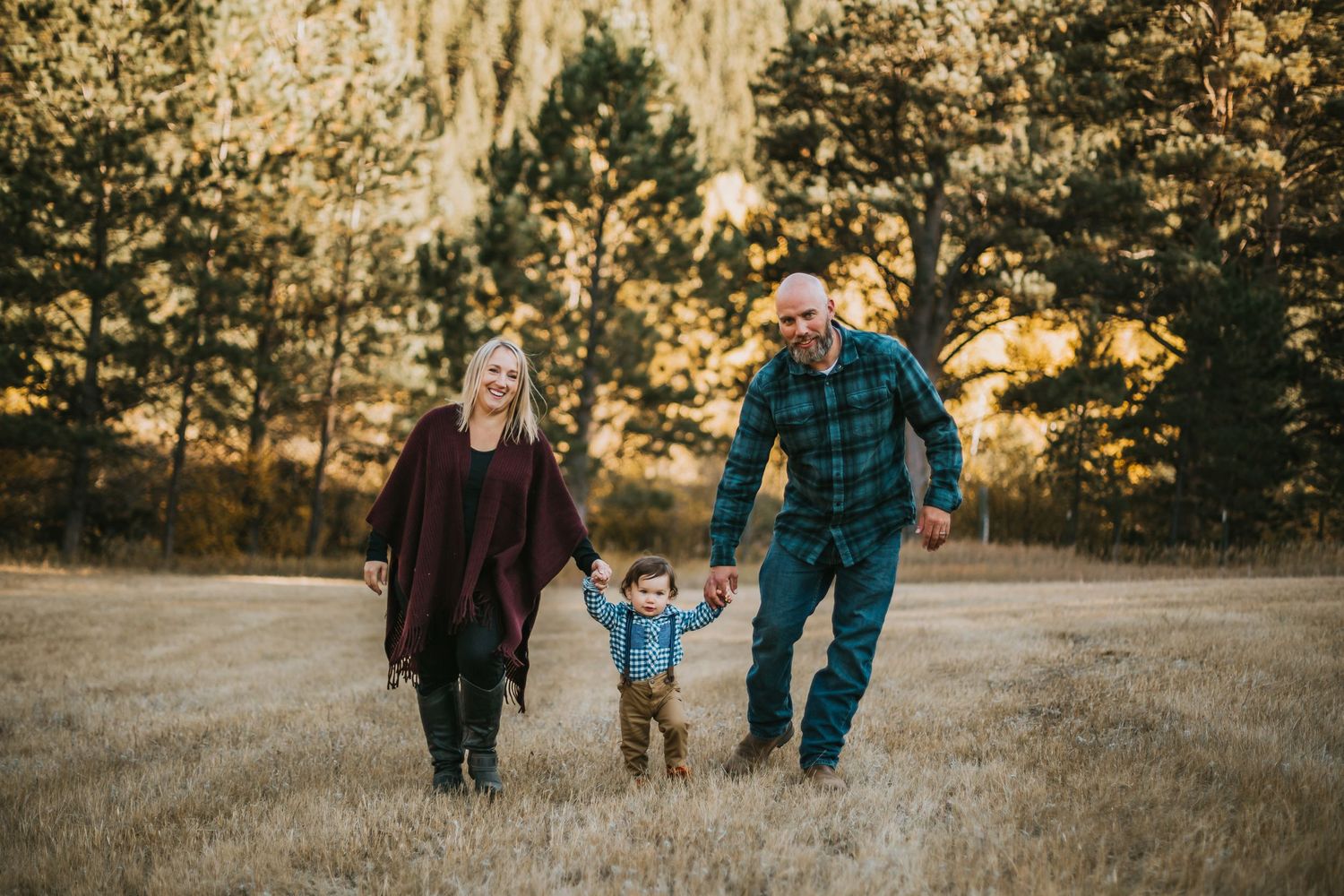 Family holds hand as they walk through the Rocky Mountains in Colorado.