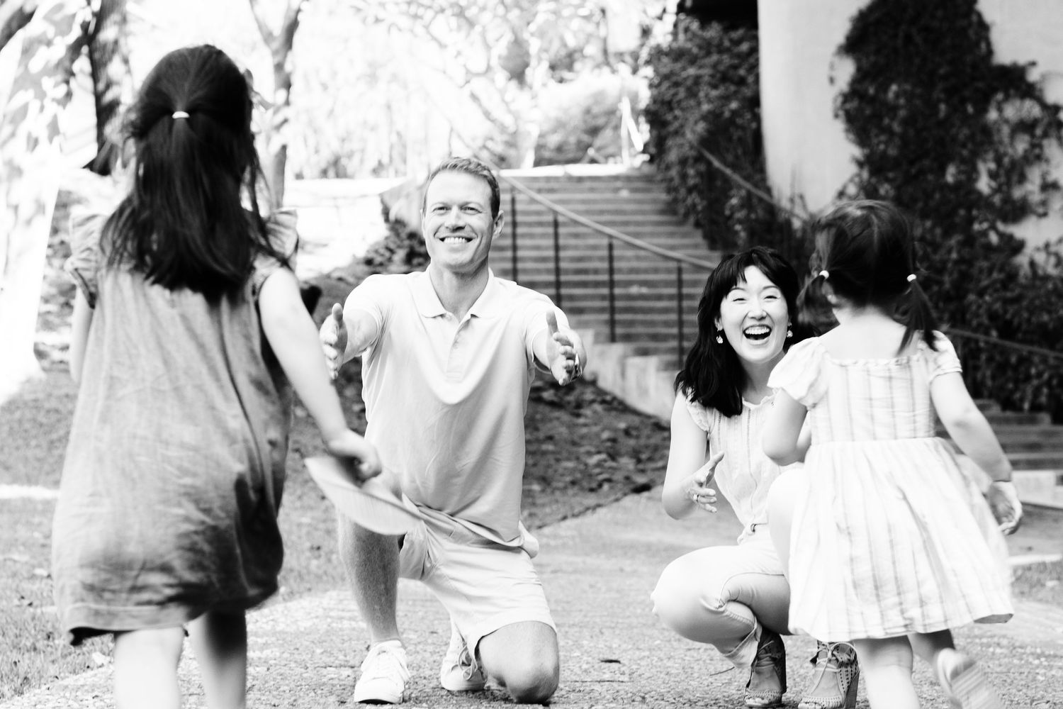 Black and white photo of playful outdoor family scene.