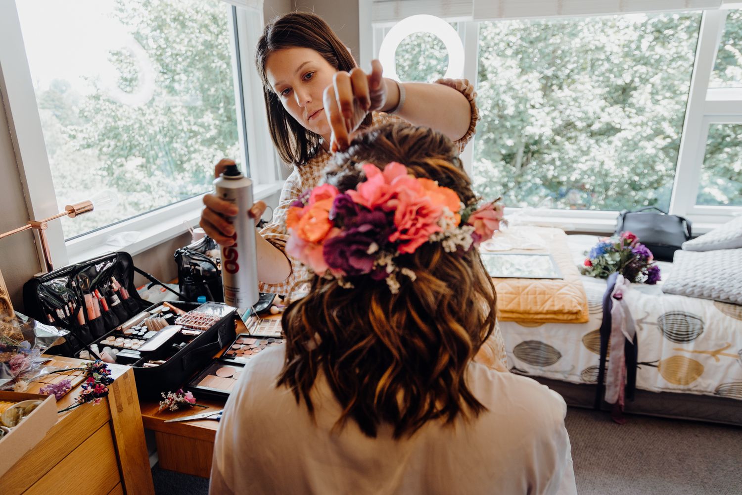 Colorful floral hair accessories being arranged during wedding preparations.