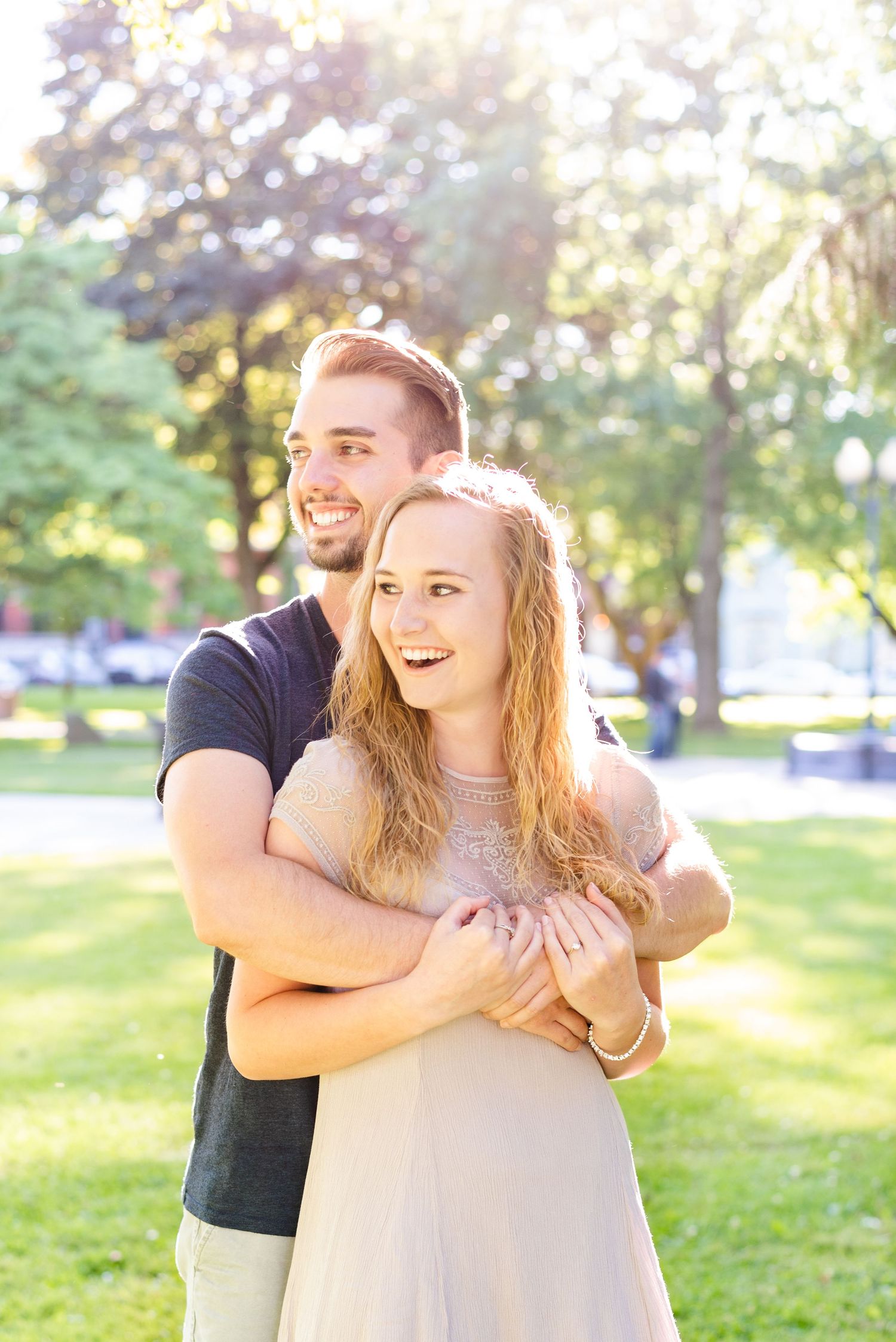 Couple standing in park in sunlight laughing for engagement in Franklin Pennsylvania