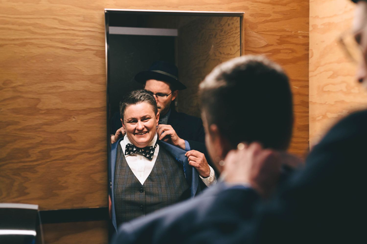 Lesbian getting ready for her wedding in suit and a bow tie