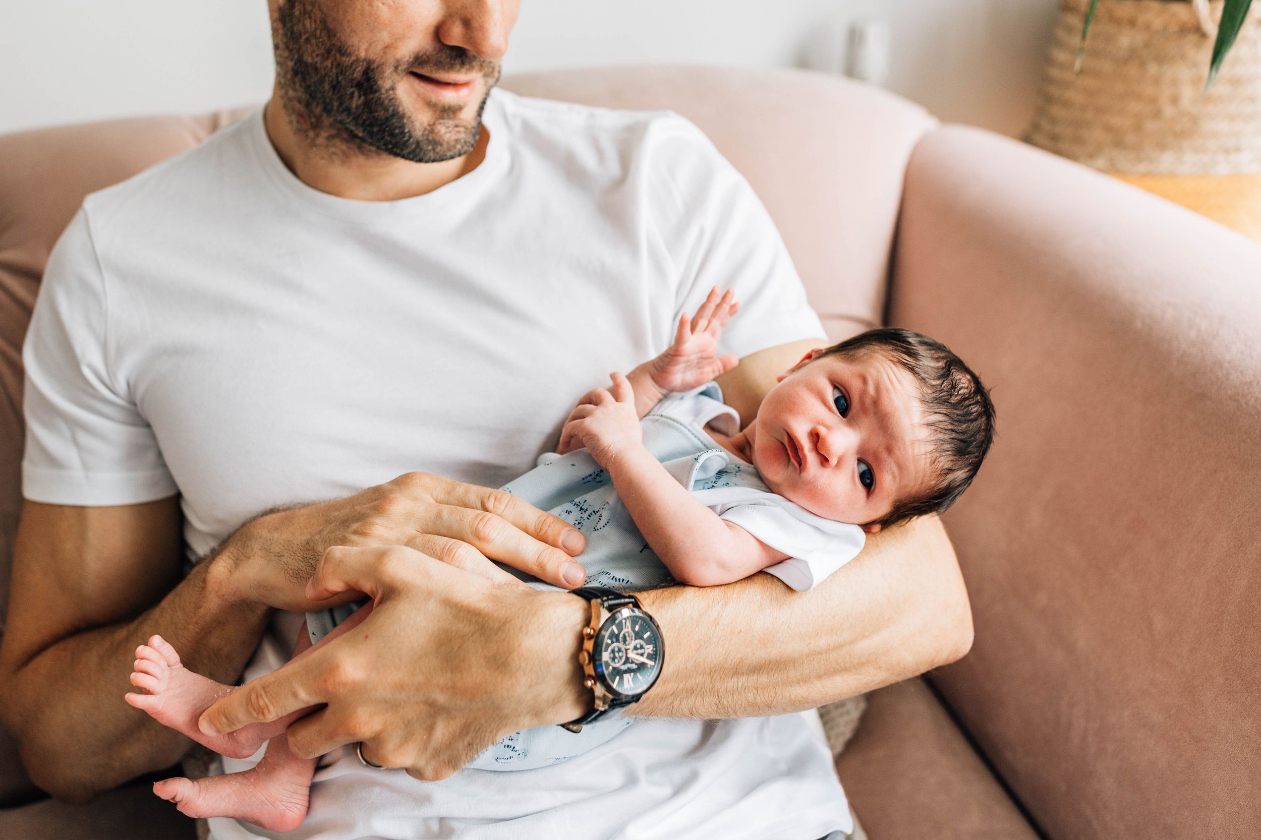 dad in white t-shirt holding little baby boy in his arms