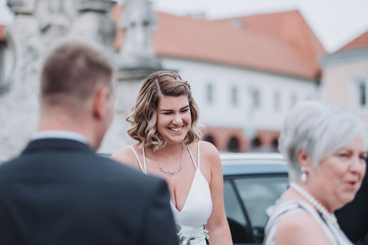 Candid moment captured during wedding celebration outside historic buildings.