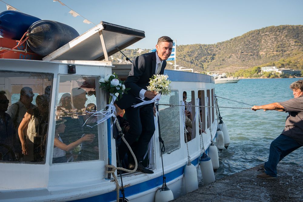 smiling groom gets out of the boat which brought him to the wedding ceremony place
