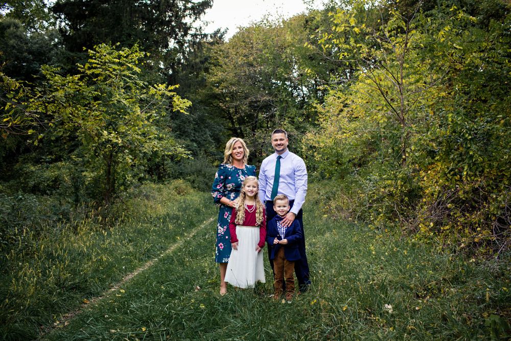 family standing in path in woods