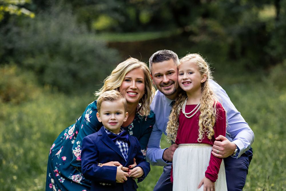 family smiling with cheeks all touching