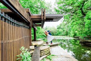 Couple kissing and dipping under trees at Alfred Caldwell Lily Pool Chicago summer elopement